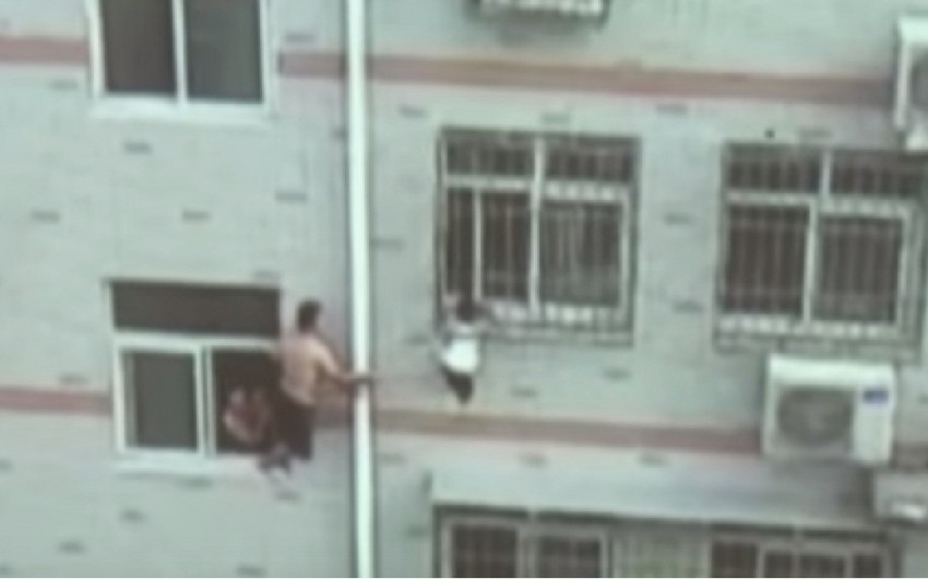 ​Китаец 20 мин шваброй держал выпавшую из окна девочку