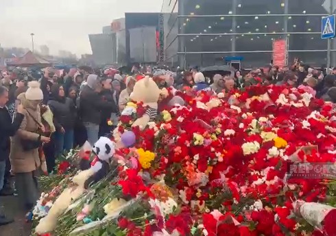 Жители Москвы несут цветы к стихийному мемориалу у 