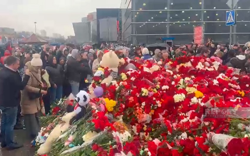 Жители Москвы несут цветы к стихийному мемориалу у Крокус Сити Холла